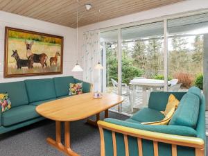 un soggiorno con divani blu e un tavolo di 8 person holiday home in Spøttrup-By Traum a Lihme