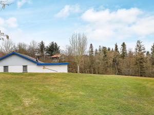 una casa bianca con il tetto blu su un campo di 8 person holiday home in Spøttrup-By Traum a Lihme Altre 11 foto