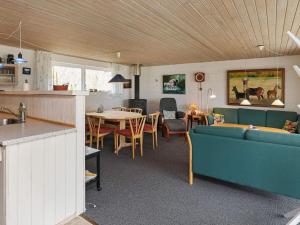 a living room with a couch and a table at Four-Bedroom Holiday home in Spøttrup 2 in Lihme