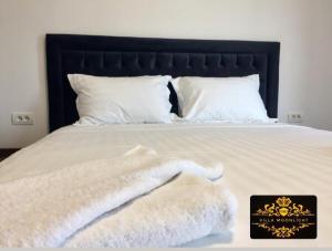 a bed with white blankets and pillows on it at Casa Moonlight 2 Mai in 2 Mai