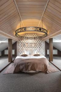 a bedroom with a large bed and a large chandelier at Stara Pravda Hotel in Bukovel