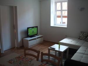 a living room with a tv and a couch and a table at Apartment MT Bovec in Bovec