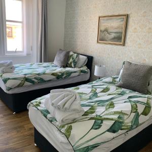 a bedroom with two beds with towels on them at Albert Road Apartment in Eyemouth