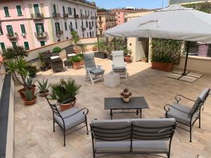 a patio with chairs and a table and an umbrella at Tuanis in Naples