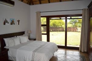a bedroom with a large bed and a large window at 86 Zebula 12 Sleeper Lodge in Mabula +48 photos