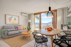 a living room with a couch and a table and chairs at Auborada 1A in Port de Pollensa