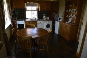 une cuisine avec une table en bois, une table et des chaises dans l'établissement Seaview Self-Catering, à Allihies