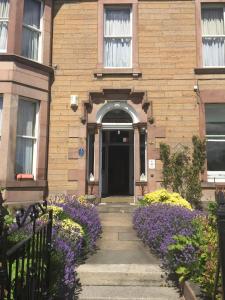 una casa di mattoni con fiori viola di fronte di Dorstan House a Edimburgo