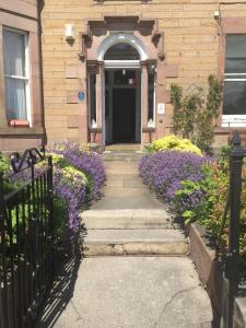 una casa con flores púrpuras delante de una puerta en Dorstan House en Edimburgo