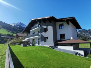 a house with a green lawn in front of it at Landhaus Rosner in Dorfgastein