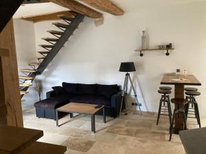 a living room with a couch and a staircase at La Grange in Avallon