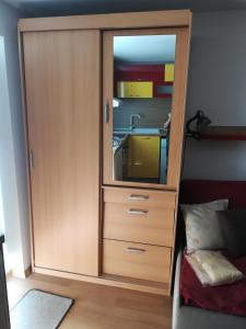 a wooden cabinet with a mirror in a bedroom at Studio Yana *Top location*Sea Garden* in Varna City