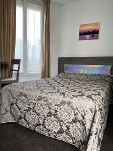 - une chambre avec un lit doté d'une couette et d'une fenêtre dans l'établissement Aero Hotel, à Issy-les-Moulineaux