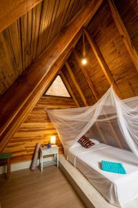 a bed in a room with a wooden ceiling at Casa del Sol in Montañita