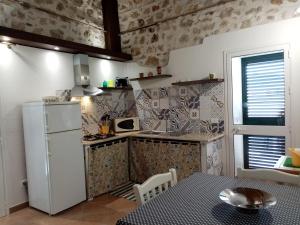 a small kitchen with a refrigerator and a table at Casa vacanze Krimisòs in Castellammare del Golfo