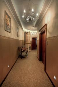 a hallway with a chandelier and a chair in a building at Pokoje Sopockie in Sopot
