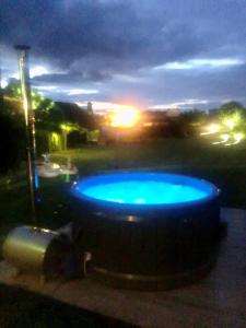a large blue pool with the sunset in the background at Dworek in Szonowice