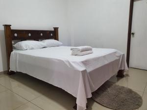 Una cama blanca con sábanas blancas y almohadas. en Limon Condos near LIO Intl Airport - 777L , Self Check-in, en Puerto Limón