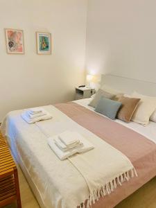 1 dormitorio con 1 cama con 2 toallas en Modern City Apartment en Módena