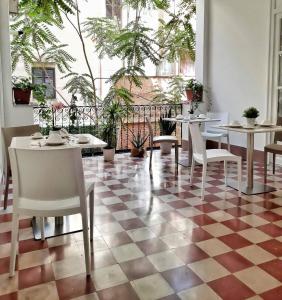 - un restaurant avec des tables et des chaises sur un sol en damier dans l'établissement Ai Quartieri, à Palerme