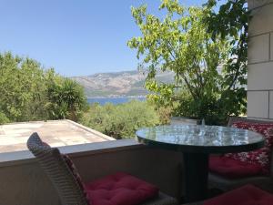 uma mesa de vidro numa varanda com vista para a água em Villa Conte em Korčula