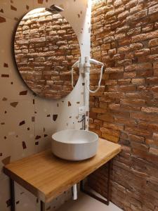 een badkamer met een wastafel en een bakstenen muur bij L'Ospitale dei Brilli in Stia