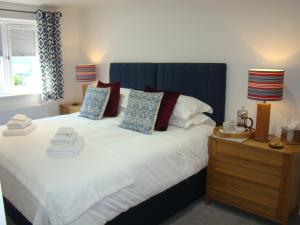 Un dormitorio con una cama grande con cabecero azul. en Topsail, Falmouth, en Falmouth