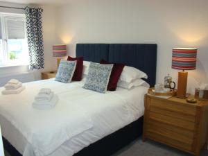 a bedroom with a large bed with a blue headboard at Topsail, Falmouth in Falmouth