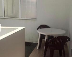 einen Tisch und Stühle in einer Küche mit einem weißen Tisch und Stühlen in der Unterkunft ESTUDIO VILA PRAIA DE ÂNCORA in Vila Praia de Âncora