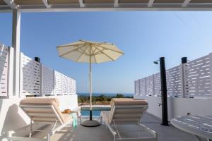 um pátio com uma mesa, cadeiras e um guarda-sol em Dionisos Suites em Lixúri