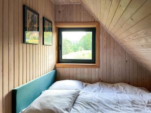 a bed in a room with a window at CHATA POD SOSNĄ in Czaszyn
