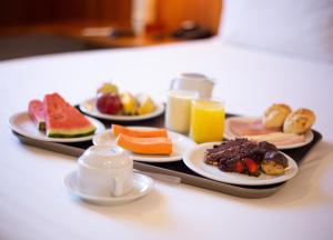 una bandeja con platos de comida en una mesa en Executive Inn Hotel en Uberlândia