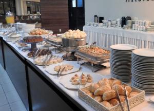 uma linha de buffet com vários tipos de pastelaria e pão em Executive Inn Hotel em Uberlândia