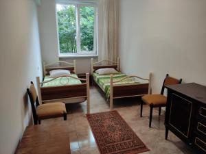 a room with two beds and a table and chairs at Hostel on the river in Batumi