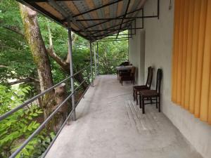 a porch of a house with chairs and a table at Hostel on the river in Batumi