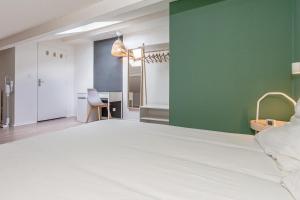 um quarto com uma cama branca e uma parede verde em matcha wood - matcha home Koenigsmacker em Koenigsmacker