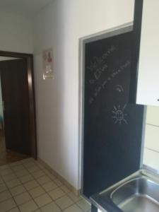 une cuisine avec un évier et un panneau mural dans l'établissement Apartments Eliva, à Umag
