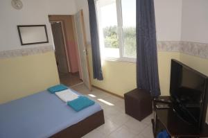 a small bedroom with a bed and a television at Lenny in Kranevo