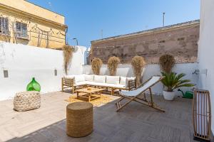 eine Terrasse mit weißen Möbeln und Pflanzen auf einem Gebäude in der Unterkunft Terrazza Vallisa in Bari