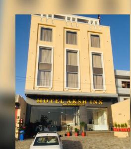 una macchina bianca parcheggiata di fronte a un edificio di Hotel Aksh Inn a Jaipur