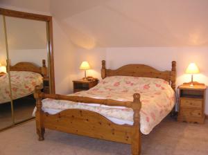 ein Schlafzimmer mit einem Bett und einem Spiegel in der Unterkunft The Antlers in Lybster + 14 Fotos