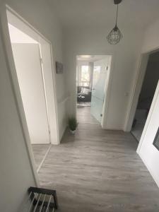 an empty hallway with white walls and a hallway with a door at Apartment Am Grünen Park in Erfurt