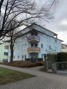 a large white building with a balcony on it at Apartment Am Grünen Park in Erfurt +2 photos