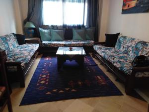 Sala de estar con sofás y mesa de centro en résidence les jardins, en El Aouina