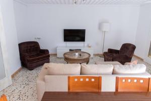 sala de estar con sofá, 2 sillas y TV en Teniente Ruiz 27 en Elche