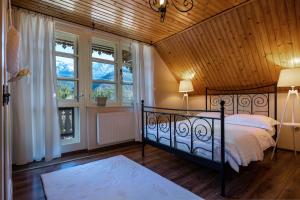 ein Schlafzimmer mit einem schwarzen Bett in einem Zimmer mit Fenstern in der Unterkunft Penzion Enrico in Ždiar