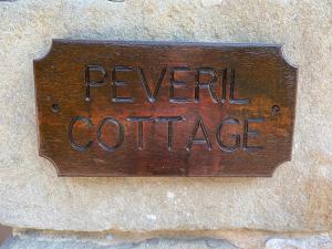 um sinal que lê revelar café em uma parede em Peveril Cottage em Castleton