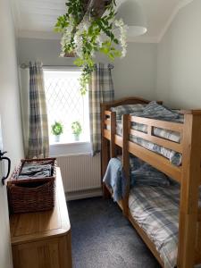 a bedroom with a bunk bed and a window at Peveril Cottage in Castleton