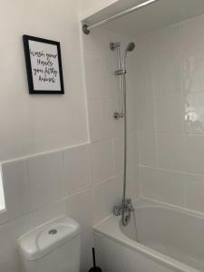 uma casa de banho branca com um chuveiro e um WC. em Peveril Cottage em Castleton