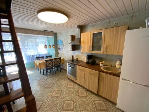 a kitchen with wooden cabinets and a dining room at Bungalow Smiltele in Nida